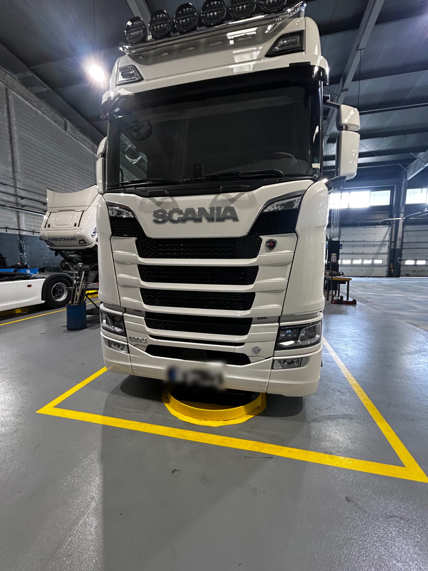 Cabeza tractora Scania blanca tras el lavado, en el taller