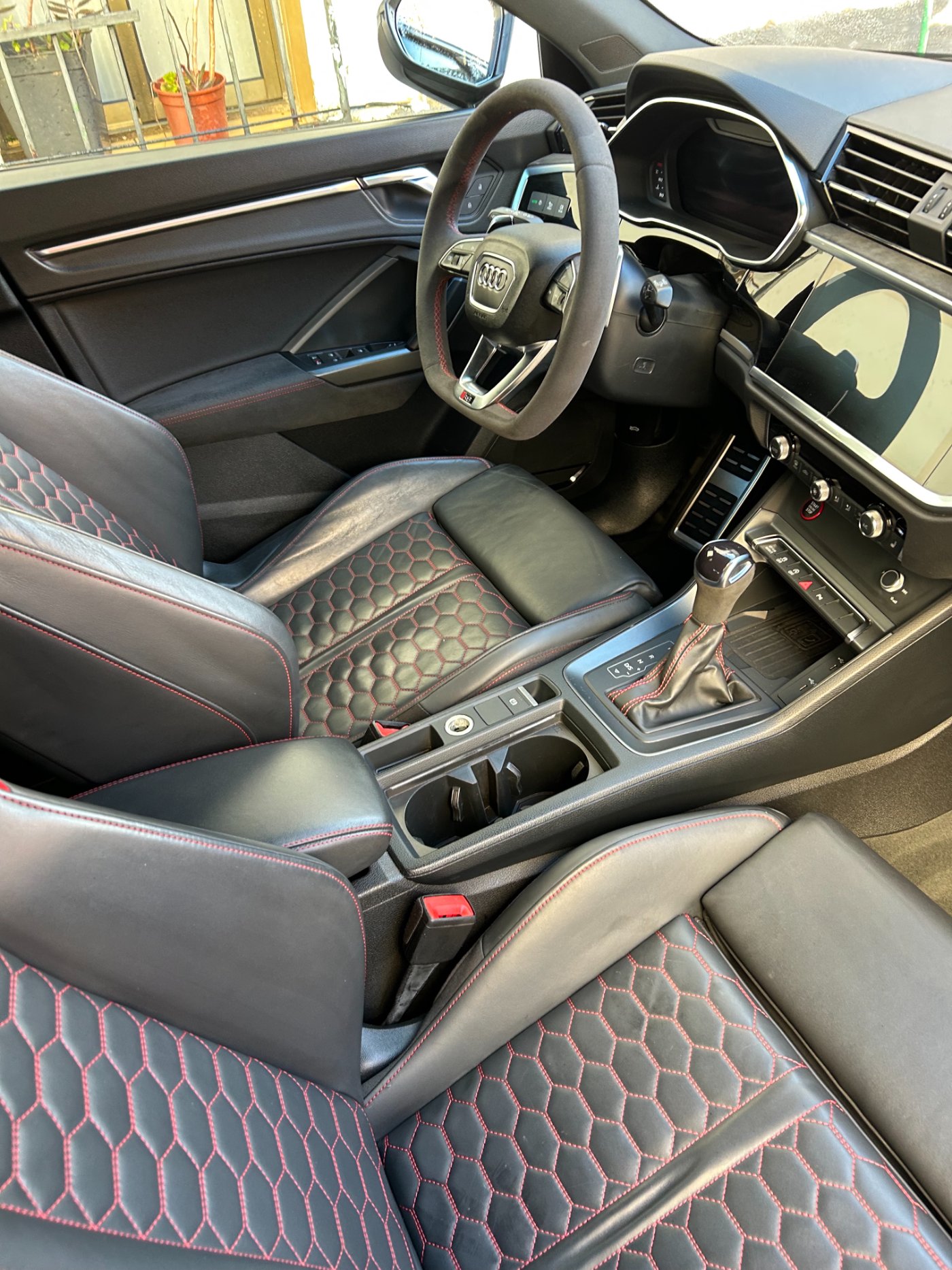Interior de cuero negro con costuras rojas tras una limpieza detallada